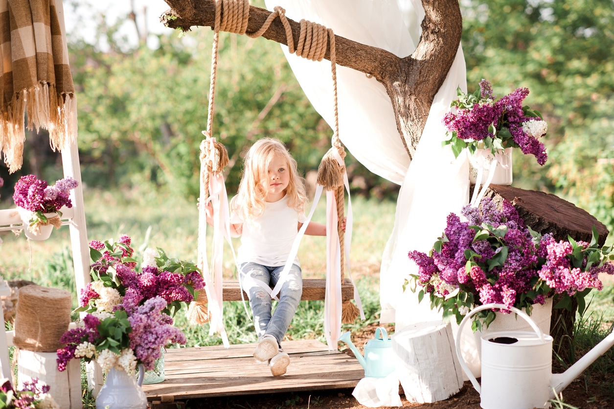 Petite fille sur balancelle dans un jardin